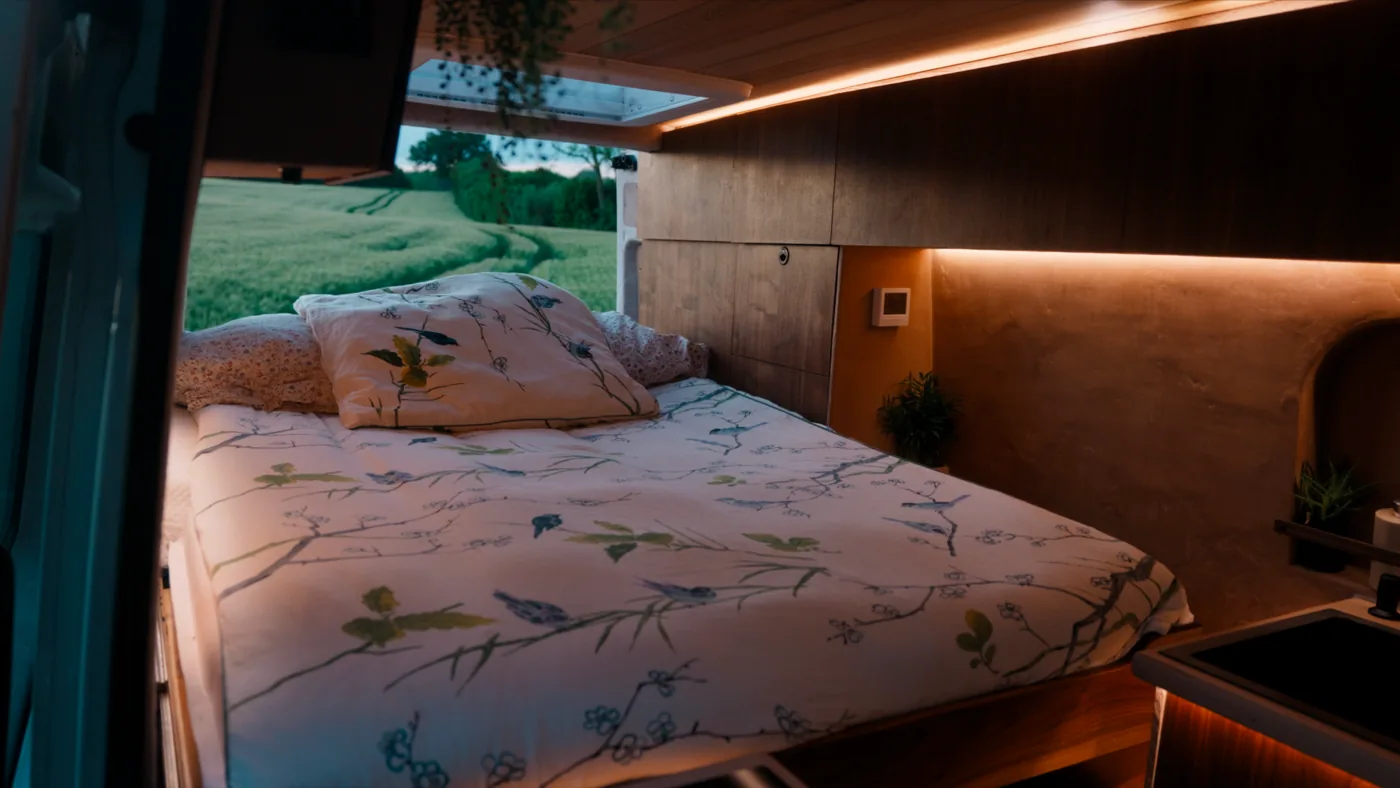 The bed extended and made up, looking out over a field